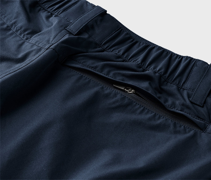 Gros plan d'un pantalon bleu marine avec une taille élastique et une poche zippée.