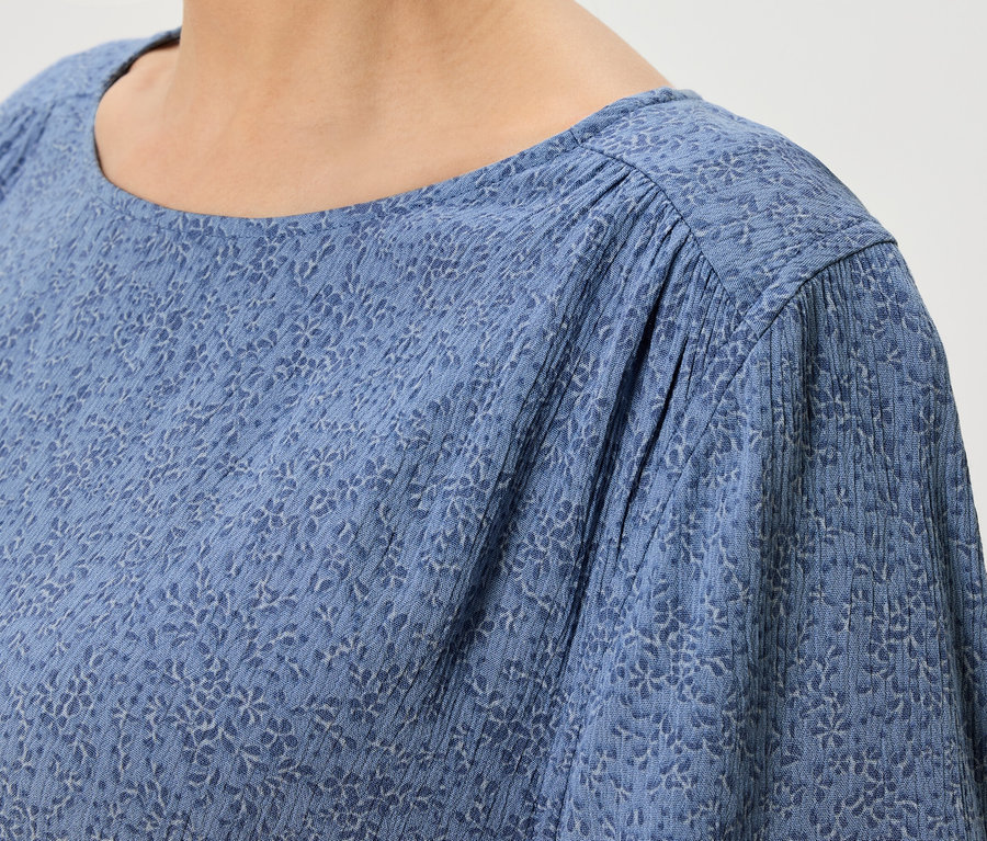 Gros plan d'un haut bleu à motif floral.