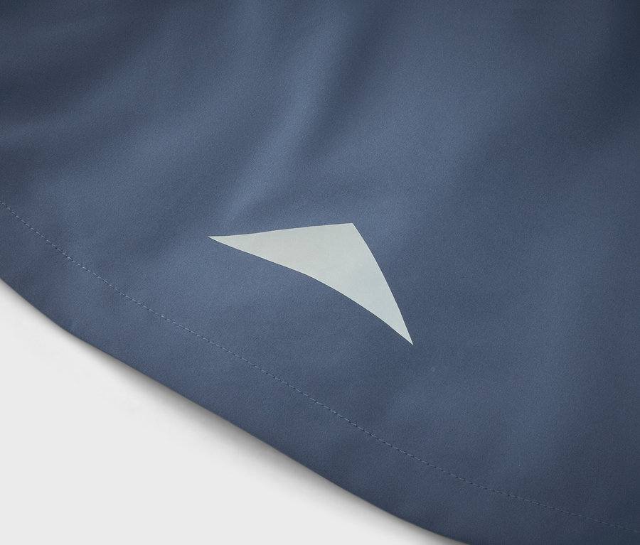 Gros plan d'un tissu bleu avec un détail triangulaire réfléchissant.