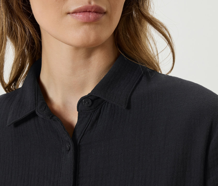 Gros plan d'une femme portant une chemise noire.