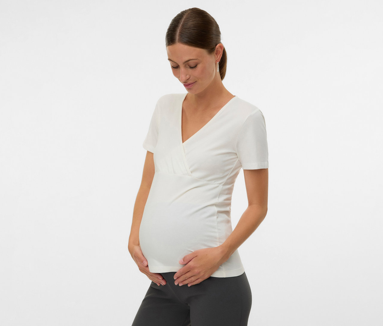 Femme enceinte tenant son ventre et portant un lot de 2 t-shirts MAMALICIOUS «
MLKERRIE TESS
» blanc.
