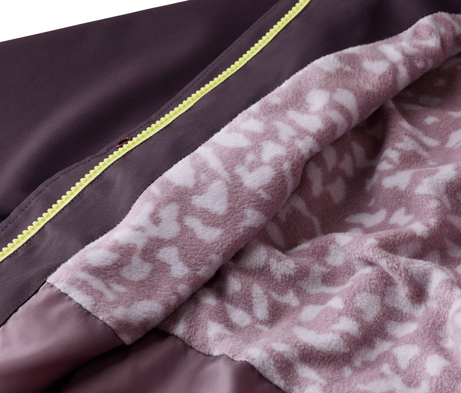 Gros plan d'une veste ouverte aubergine avec une fermeture éclair jaune et une doublure intérieure rose avec un motif blanc.