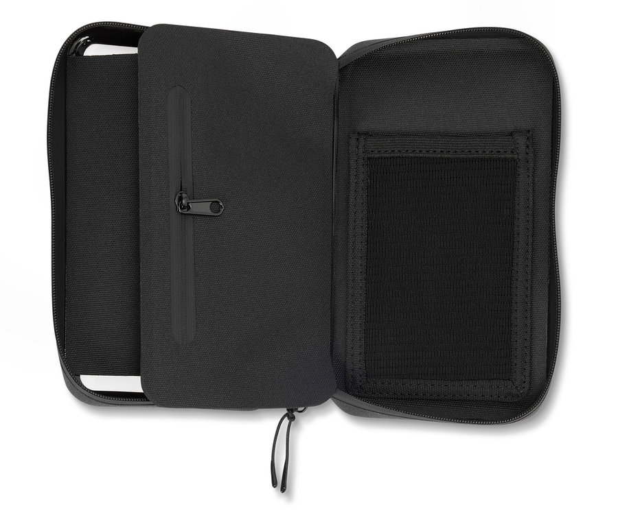 Trousse noire ouverte avec fermeture éclair, compartiments et poche intérieure zippée.