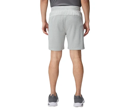 Vue arrière d'une personne portant un short court gris clair et des chaussures de course grises.