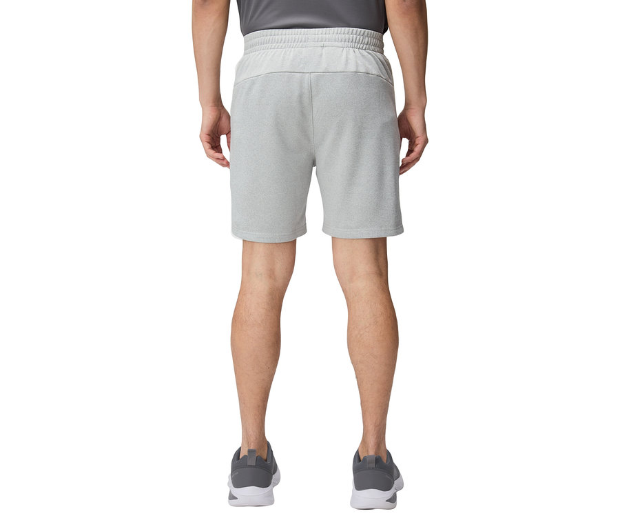 Vue arrière d'une personne portant un short court gris clair et des chaussures de course grises.