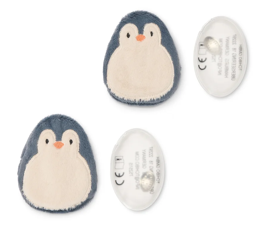 Deux objets en peluche en forme de pingouin, bleu foncé et beige, chacun à côté d'un disque ovale transparent avec du texte et un marquage CE.