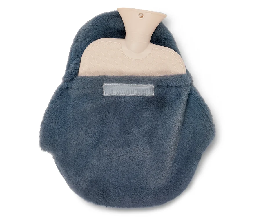 Une bouillotte beige est partiellement insérée dans une housse moelleuse gris-bleu foncé, son col étant visible en haut.