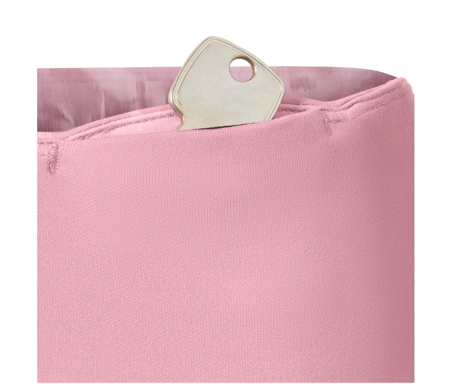 Clé argentée dans la poche d'un legging de sport réversible, rose.
