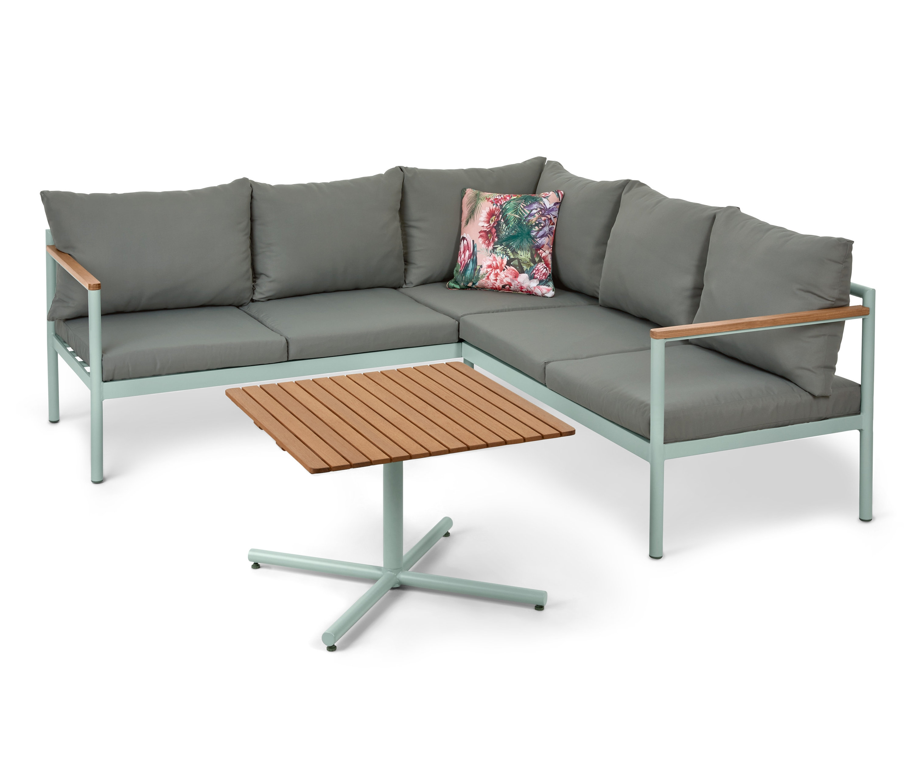 Un canapé d'angle pour le jardin avec une table. Le canapé a des coussins gris et un coussin à fleurs.