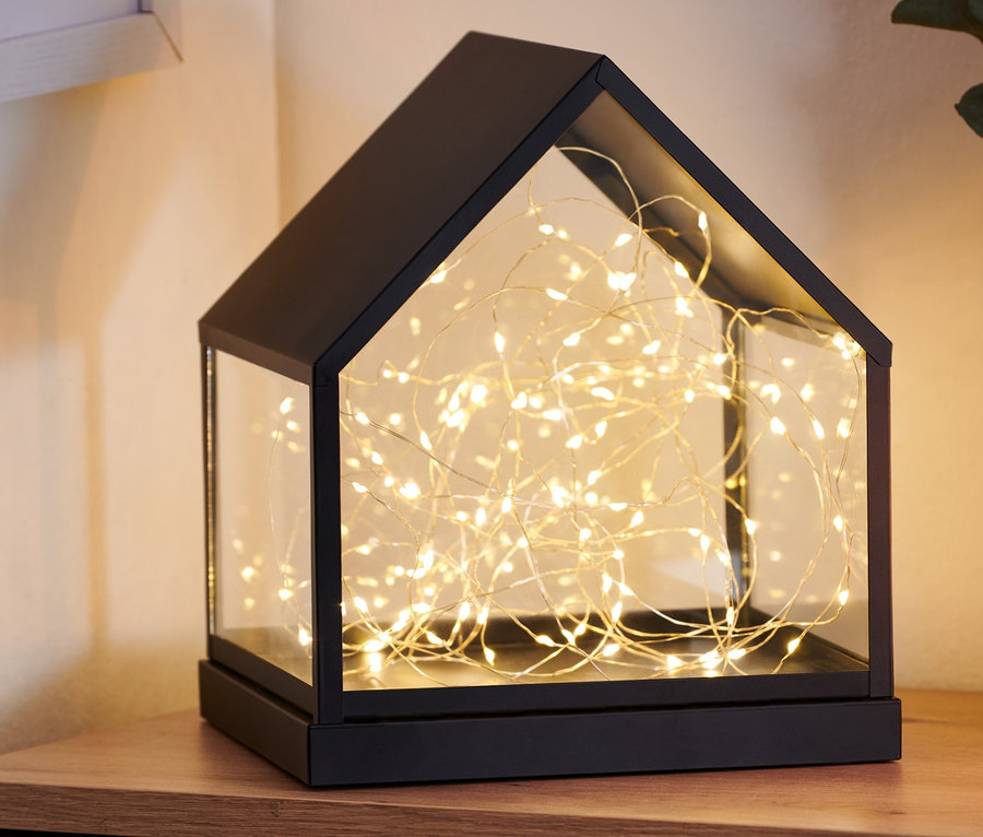 Sur une commode en bois se trouve une petite serre à LED.