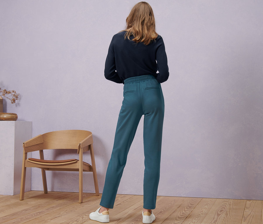 Une femme, vue de dos, porte un pantalon de jogging.