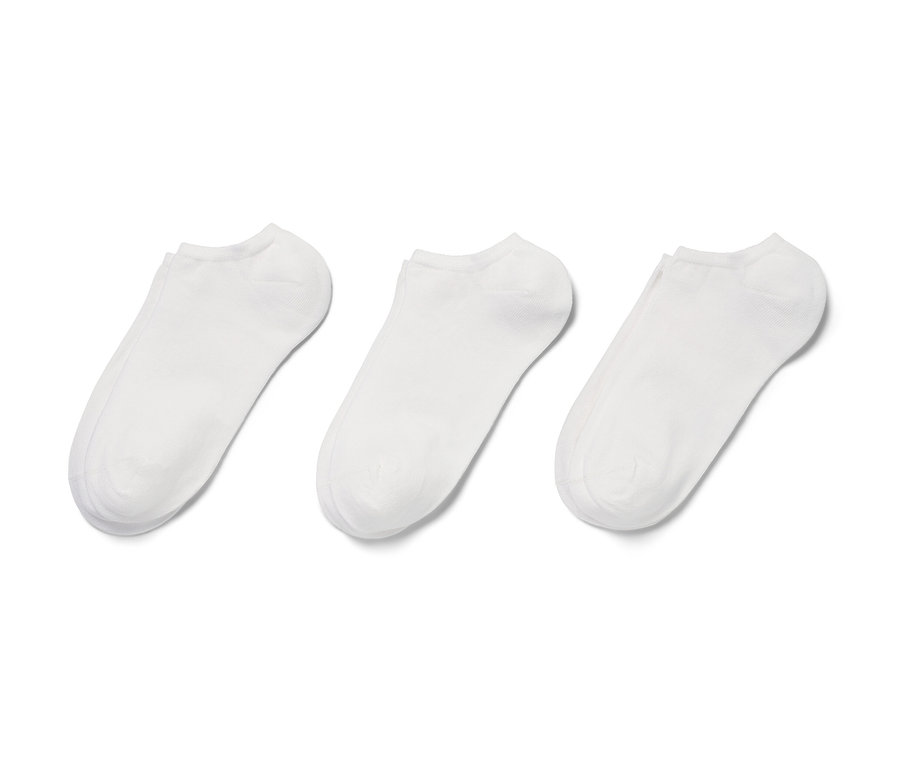 Trois paires de socquettes de sport blanches sur fond blanc.
