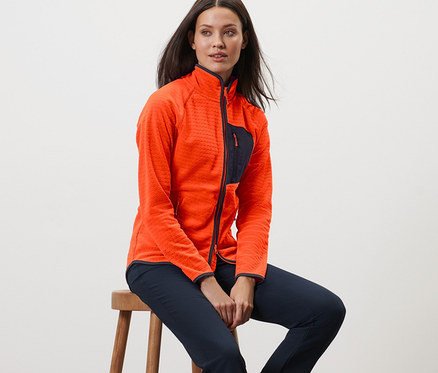 Femme assise sur un tabouret portant une jaquette en polaire.