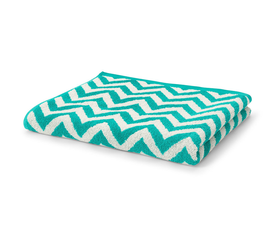 Un drap de bain en jacquard turquoise plié sur un fond blanc.
