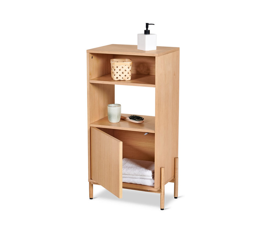 Une armoire de salle de bain avec placage bois avec deux étagères ouvertes, dont une avec un panier et une brosse. L'armoire inférieure est ouverte et contient des serviettes.