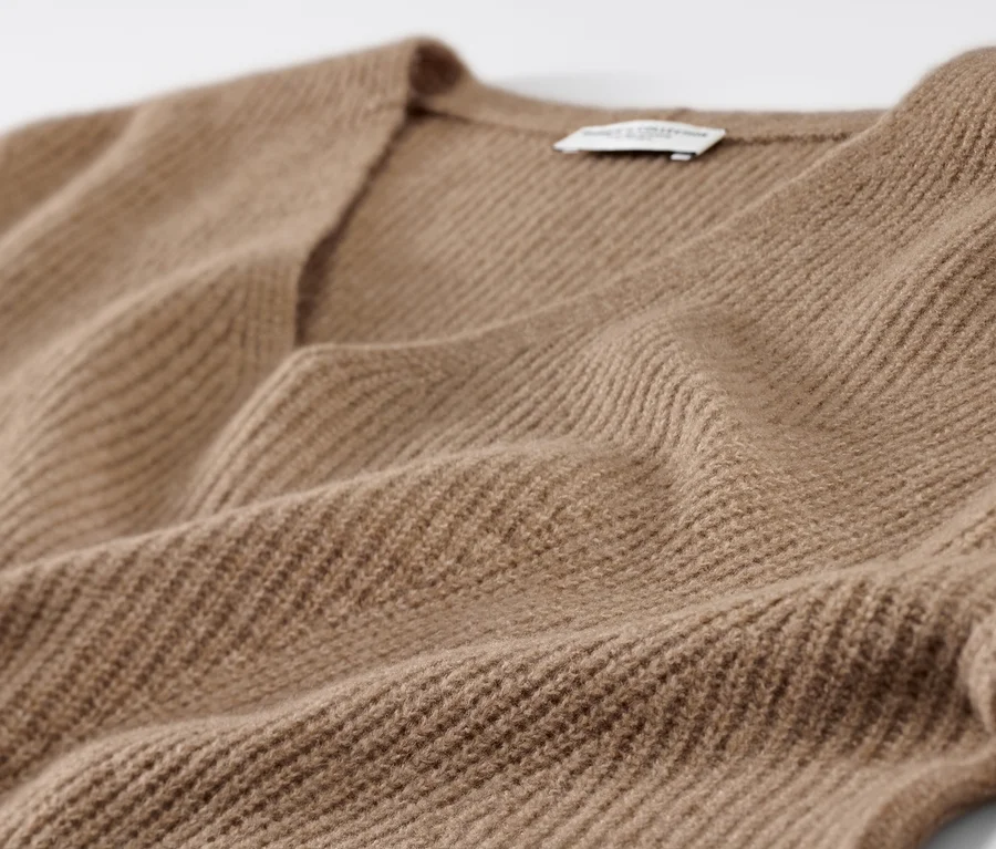Gros plan d'un pull en grosse maille camel.