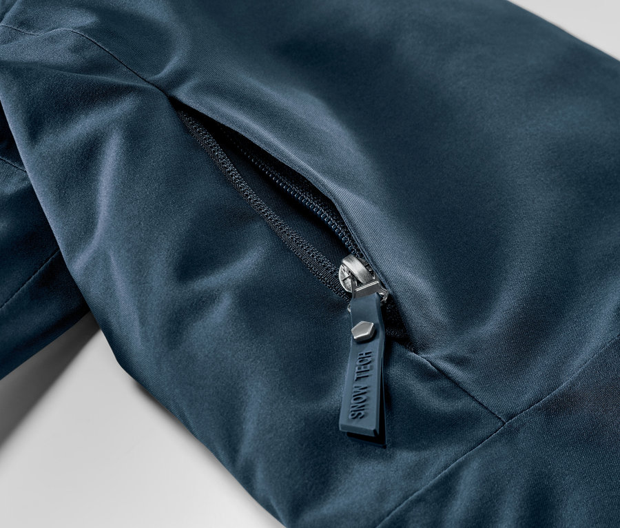 Gros plan sur une veste de ski bleu marine avec fermeture éclair.