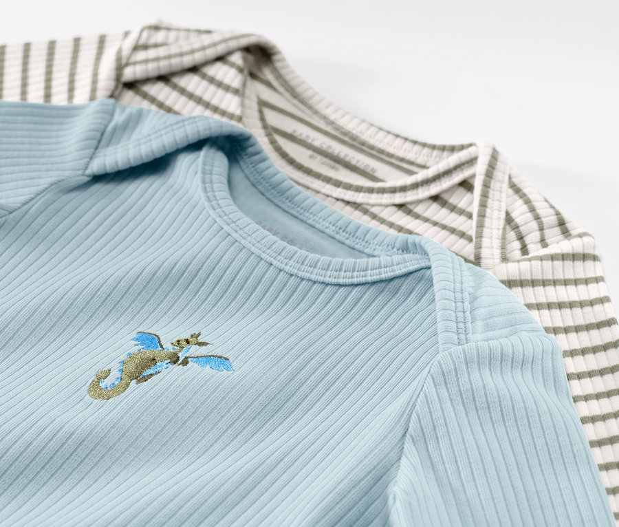 Deux t-shirts à manches longues pour bébé avec structure côtelée, bleu clair avec broderie et rayé vert et blanc.