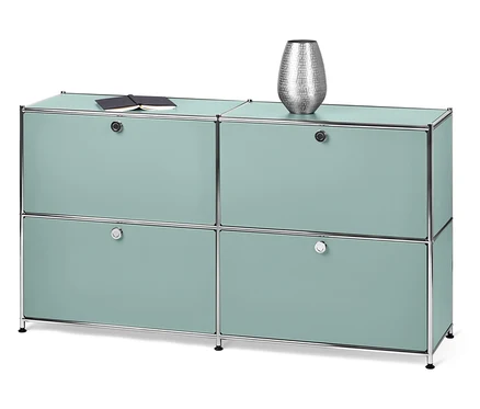 Un meuble de rangement bleu clair avec quatre portes. Un livre et un vase sont posés sur le dessus.