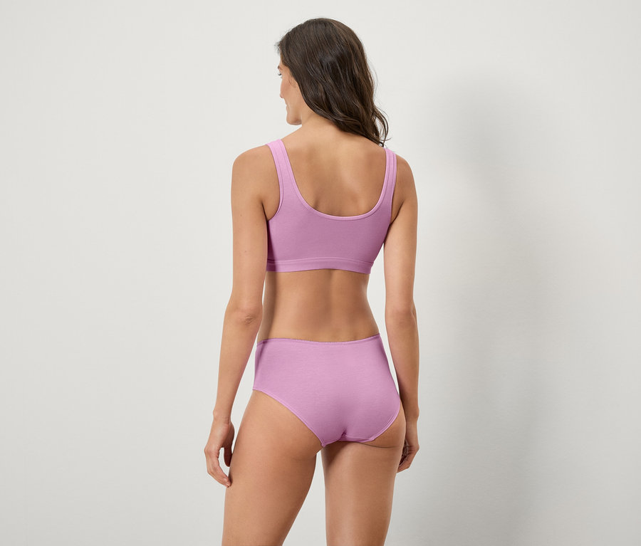 Vue arrière d'une femme aux cheveux bruns portant un soutien-gorge de sport et une culotte lilas.