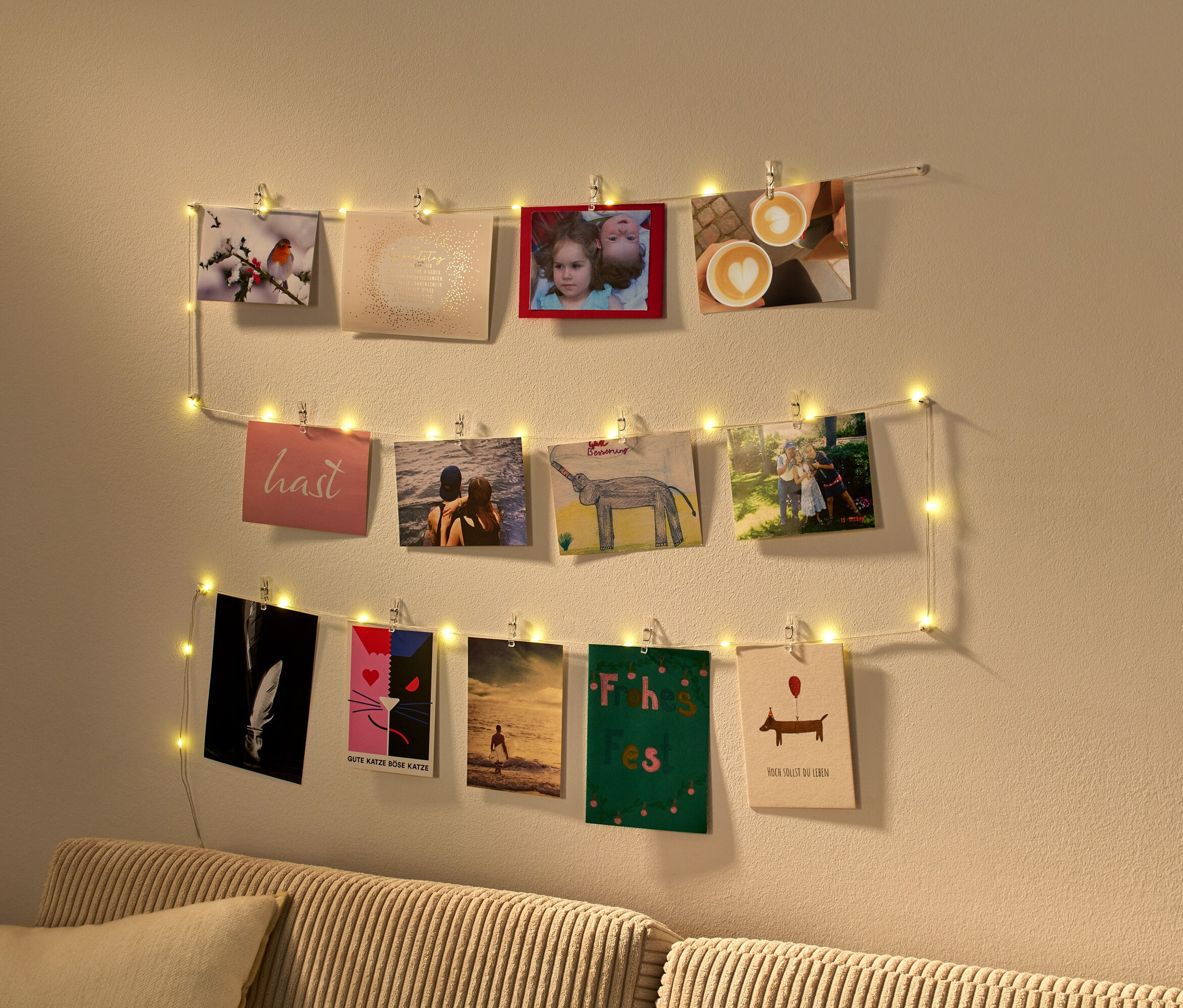 Une guirlande lumineuse à LED avec des pinces tient des photos sur un mur.