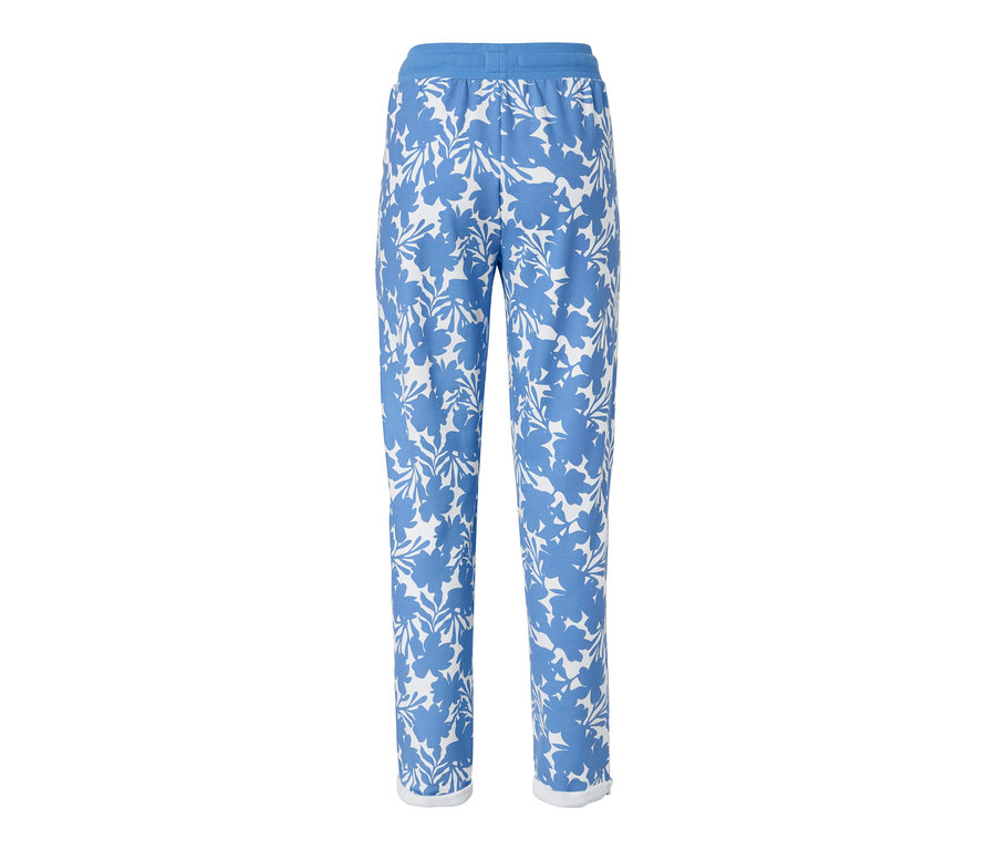 Un pantalon de survêtement bleu imprimé avec des motifs floraux sur fond blanc.