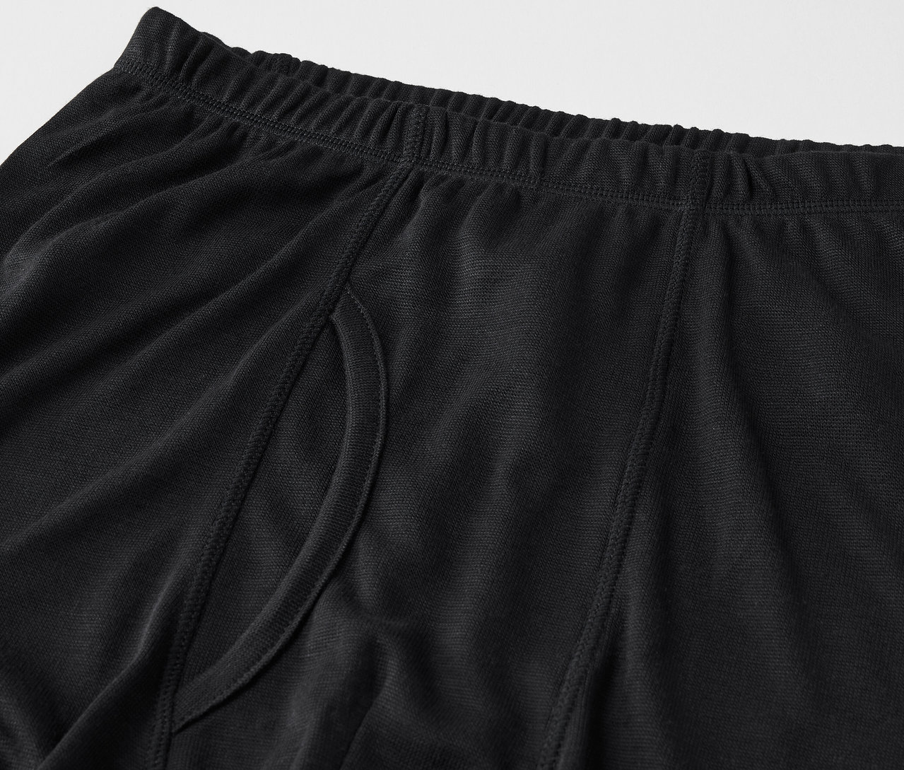 Gros plan sur un boxer noir pour homme avec une taille élastique et une fente latérale.