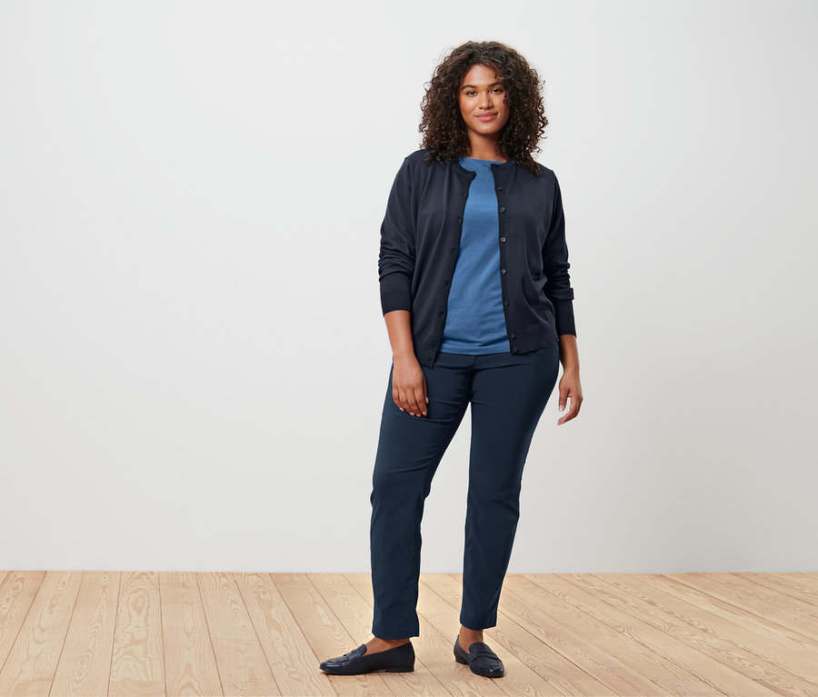 Femme portant un t-shirt bleu à manches courtes et un cardigan.
