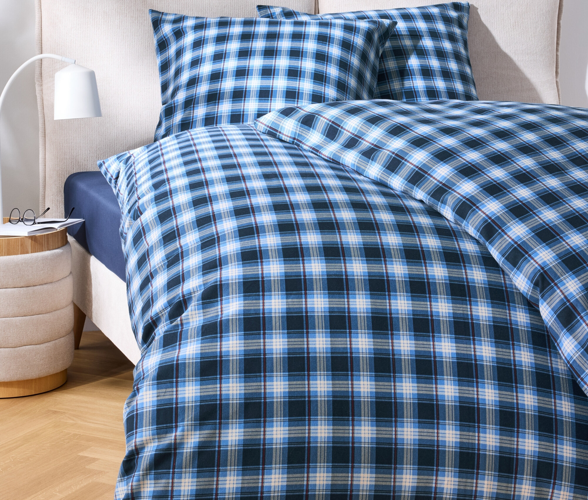 Linge de lit à carreaux bleus sur un lit.