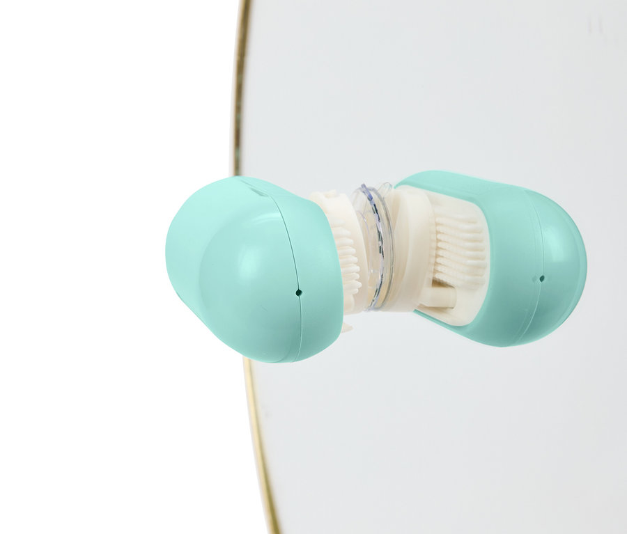 Gros plan d'une brosse nettoyante ouverte bleu clair avec des poils blancs.