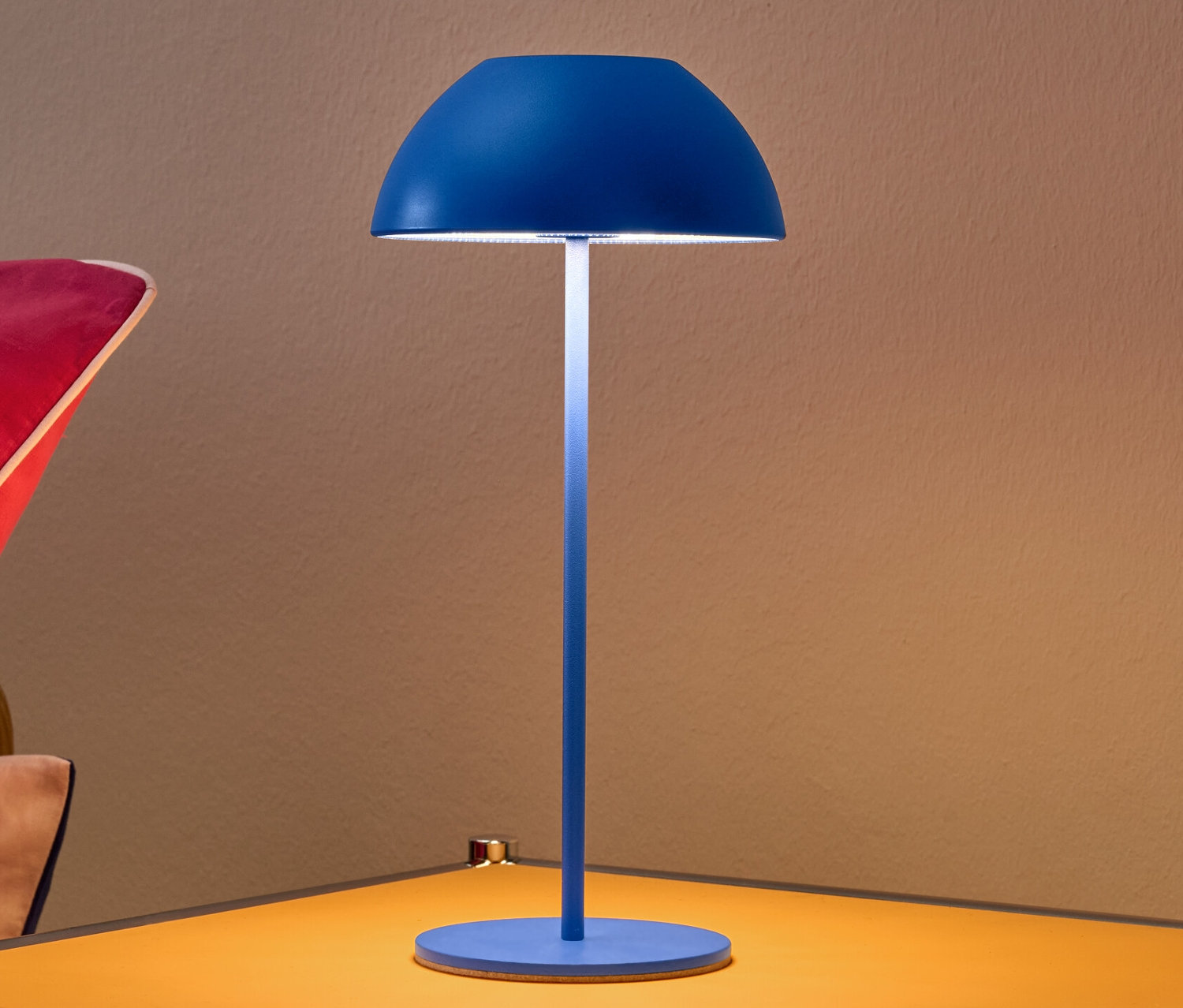 Lampe de table à LED sans fil bleue sur une table de chevet jaune.