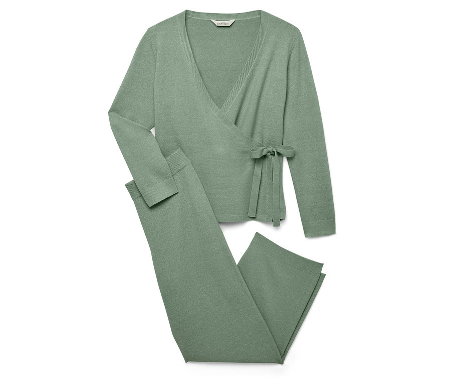 Un cardigan cache-cœur en tricot vert et un pantalon en tricot sont posés sur un fond blanc.