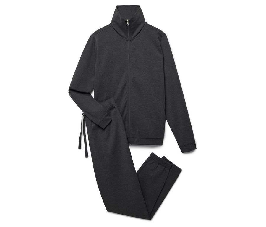 Un survêtement gris avec une veste zippée et un pantalon posé sur un fond blanc.