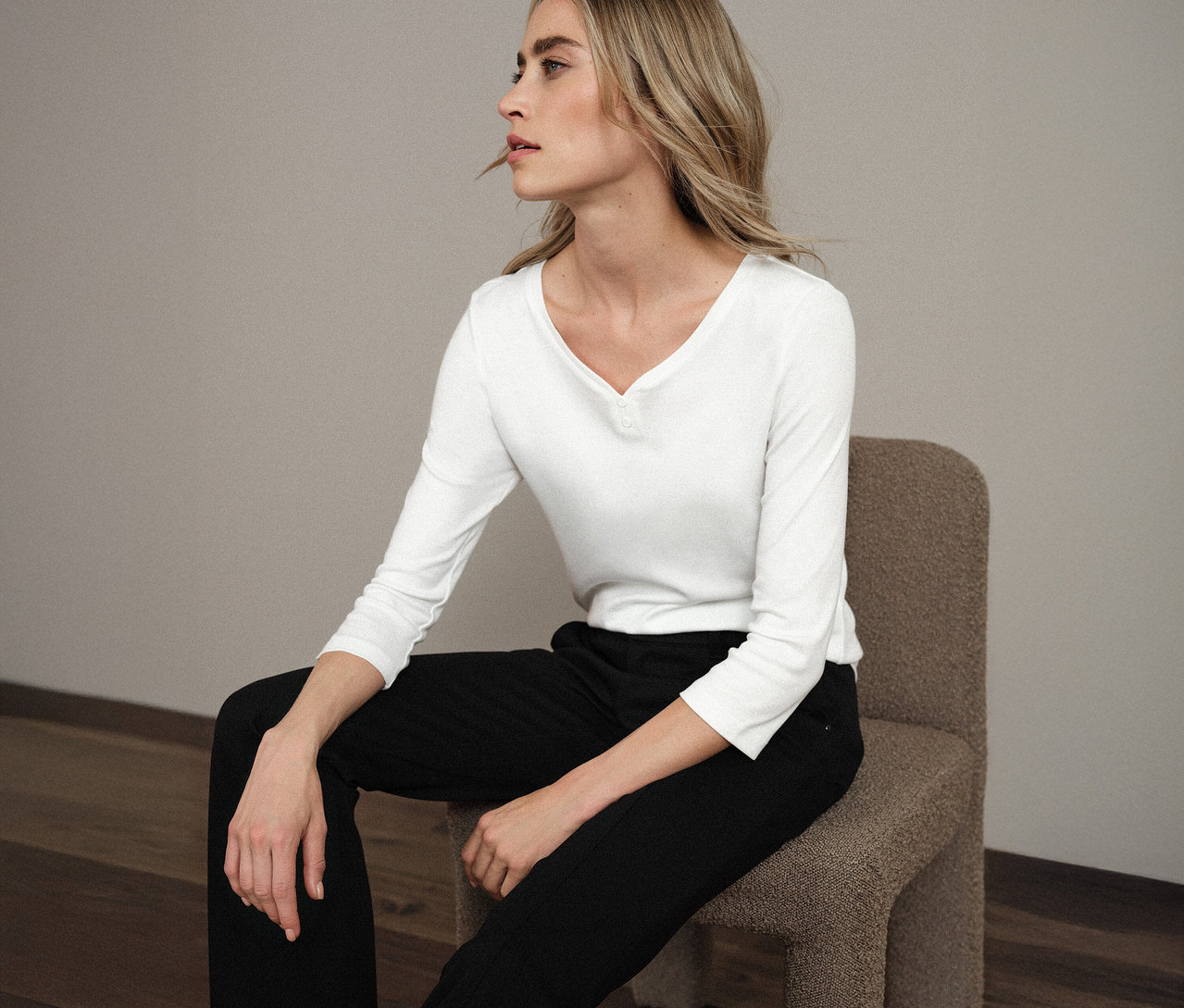 Femme assise sur une chaise portant un maillot 3/4 blanc avec détail bouton Street One.