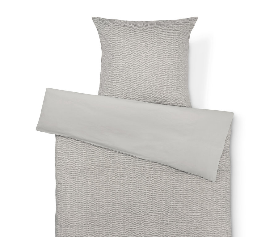 Linge de lit beige avec motif à chevrons gris et taie d'oreiller beige unie.
