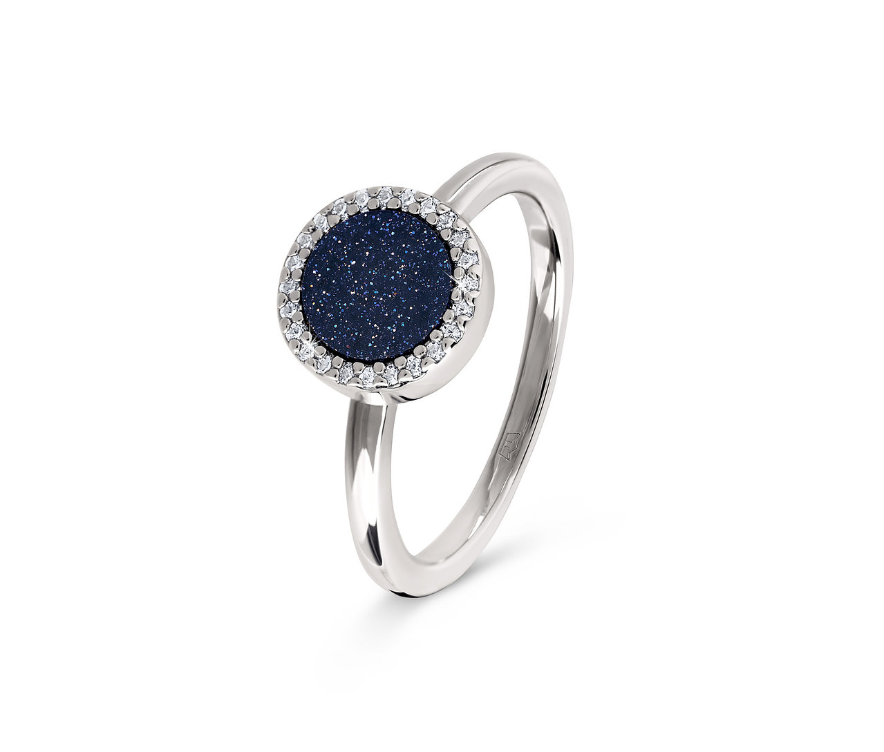 Gros plan d'une bague argentée avec une pierre ronde bleu foncé entourée de pierres transparentes.