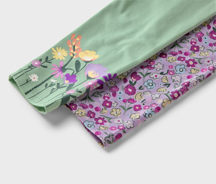 Détail de deux manches en tissu. L'une est vert clair avec des fleurs colorées, l'autre violette avec de petites fleurs.