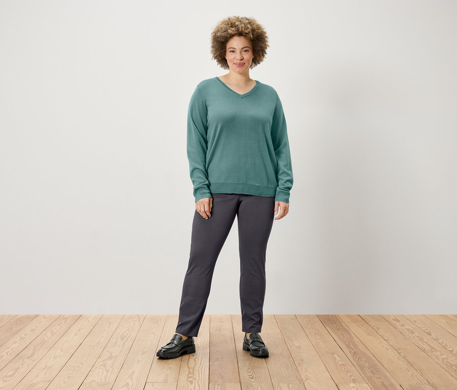 Femme posant dans un pull et un pantalon stretch.