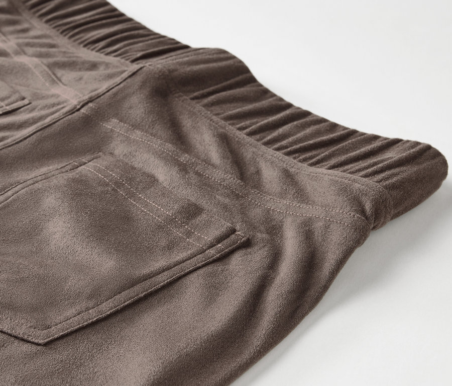 Gros plan sur un pantalon en daim marron avec une taille élastique et une poche arrière.
