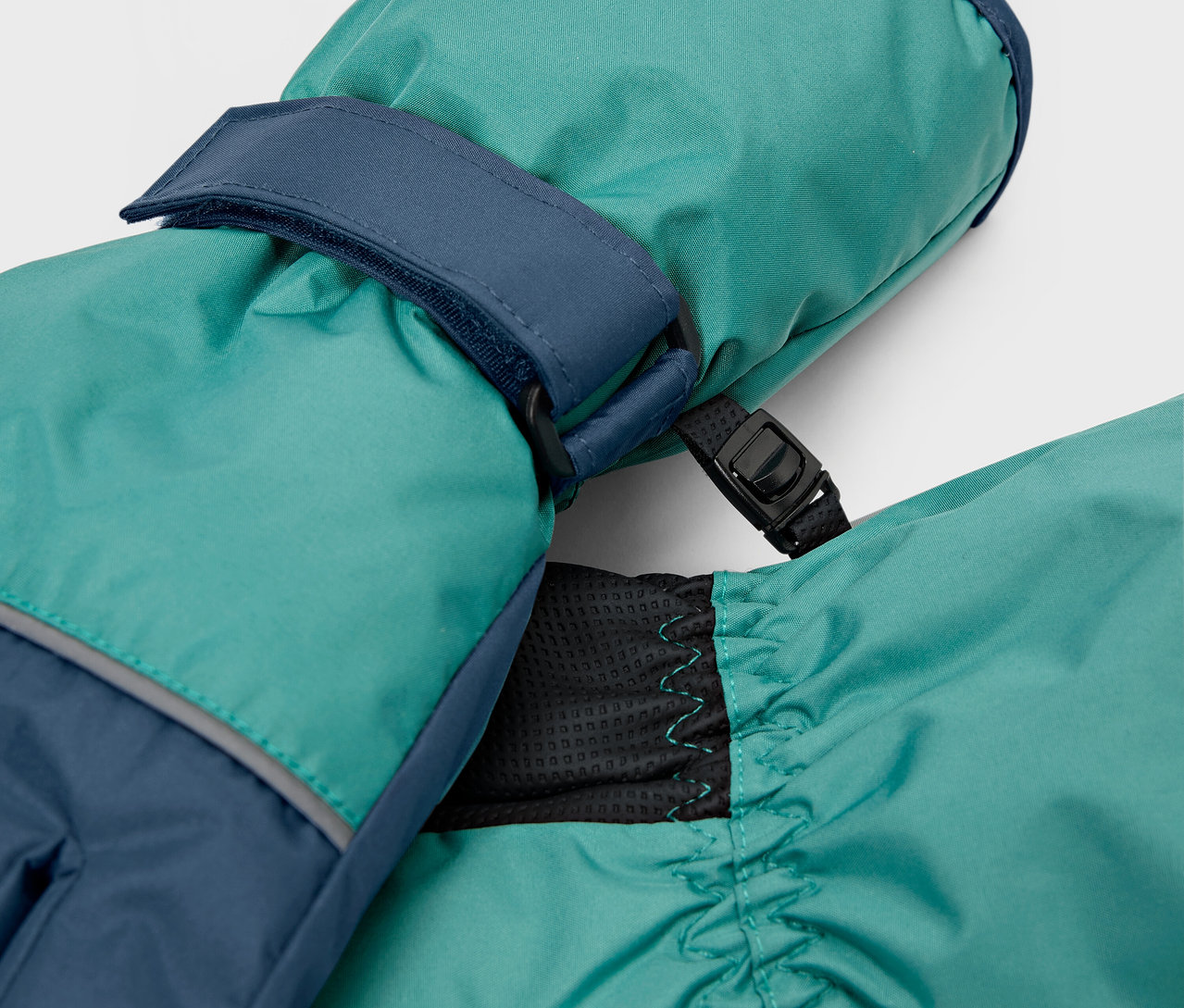 Gros plan de moufles turquoise avec des détails bleu marine.