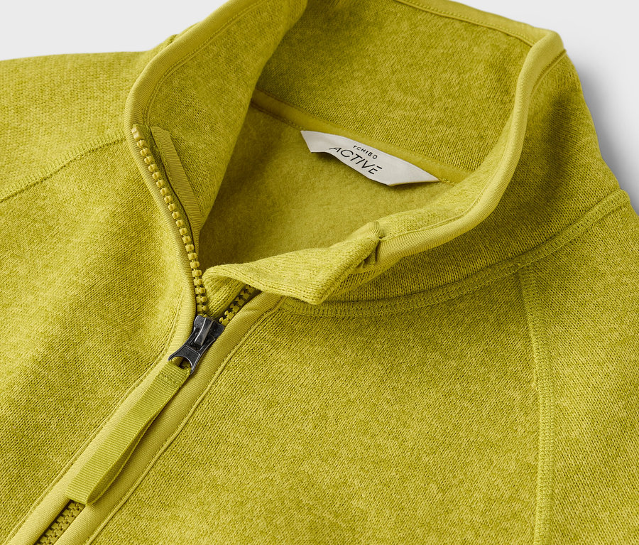 Gros plan sur un sweat à fermeture éclair Active vert-jaune.