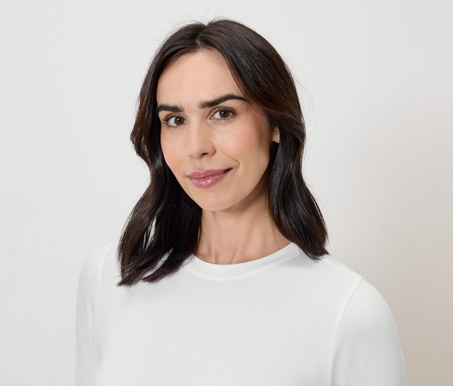 Portrait d'une femme aux cheveux foncés portant un t-shirt blanc.
