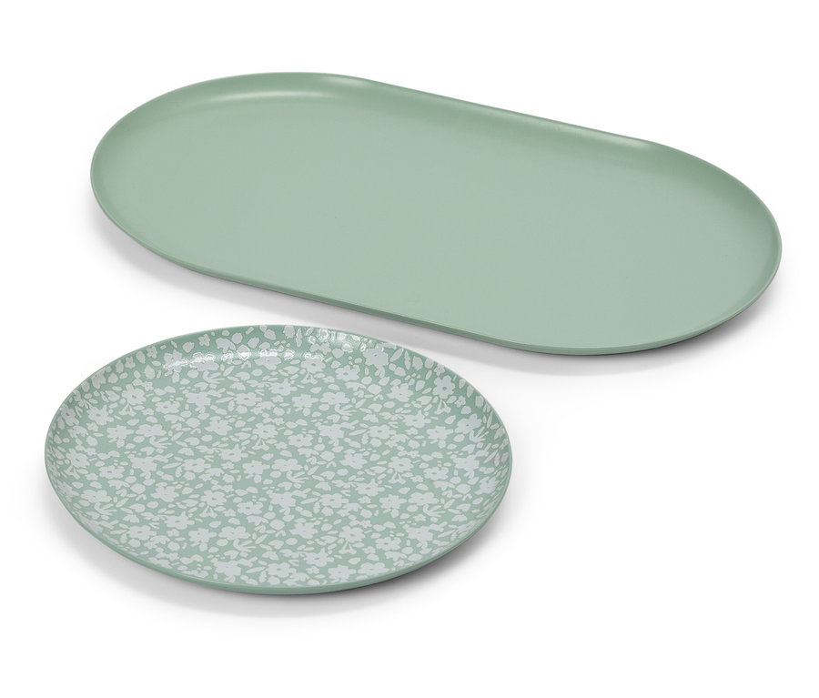 Une assiette ovale vert clair à côté d'une assiette ronde avec un motif vert clair.