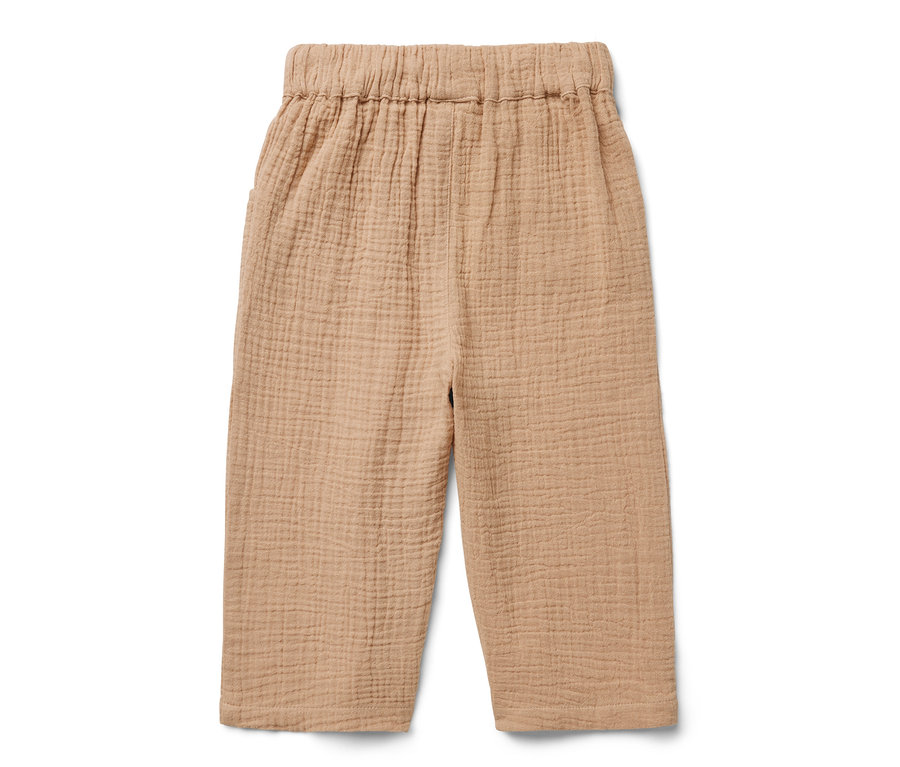 Un pantalon en mousseline pour enfant beige sur fond blanc.