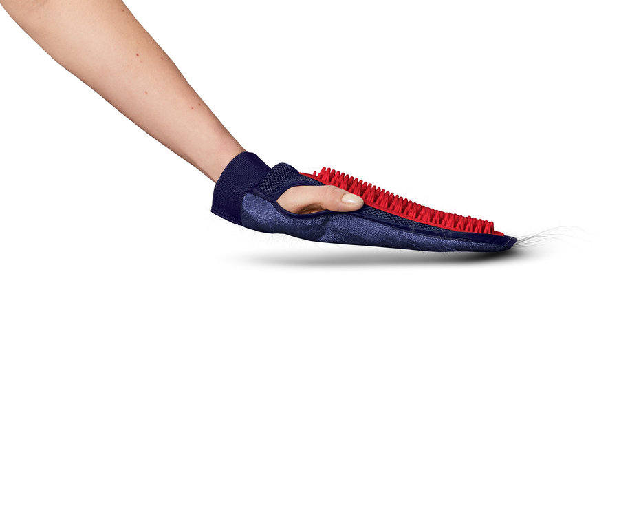 Une main tient un gant bleu avec des poils rouges, qui ramasse les poils d'animaux.