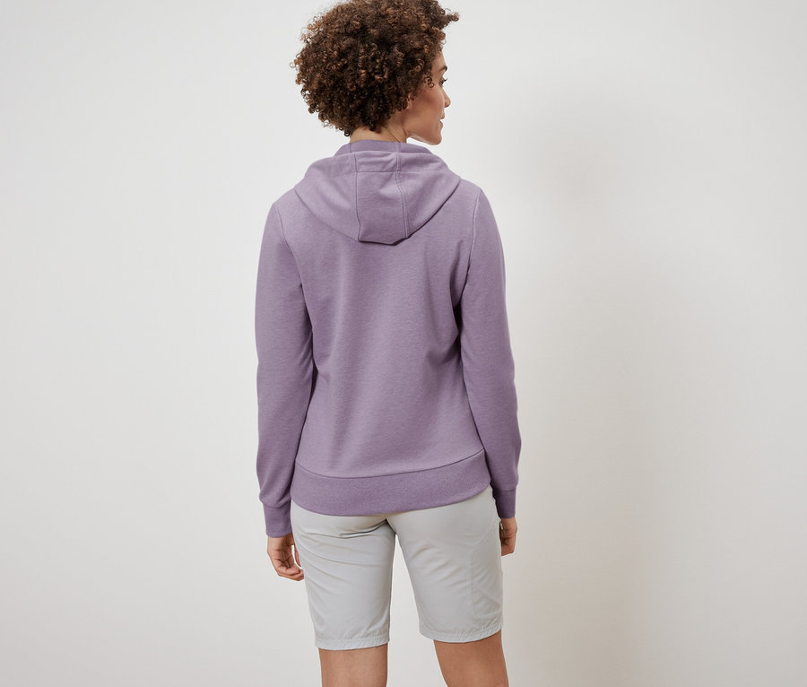 Vue arrière d'une femme aux cheveux bouclés portant une veste molletonnée et un short.