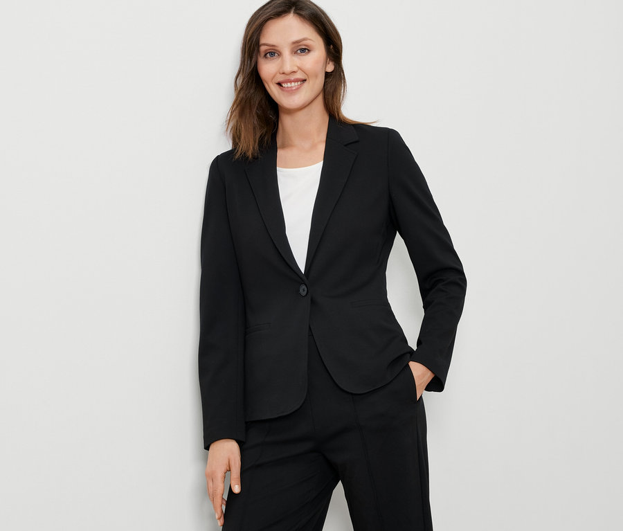 Femme portant un blazer en jersey noir.