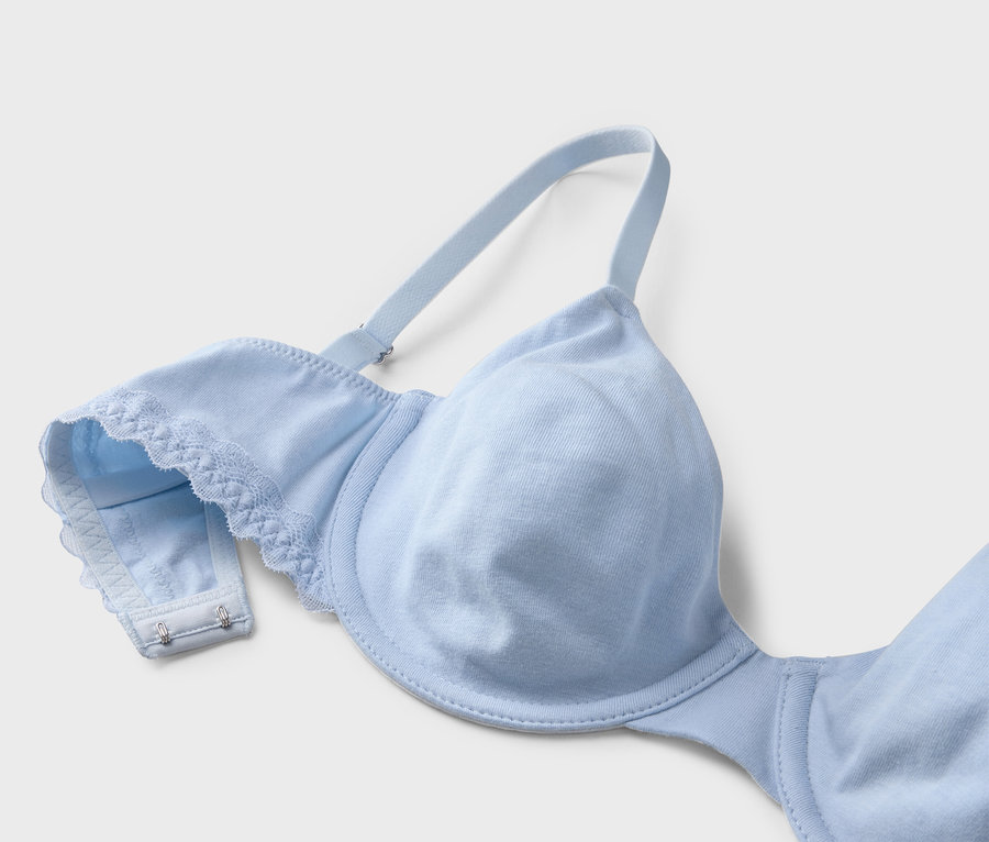 Gros plan d'un soutien-gorge bleu clair avec dentelle et bretelles réglables sur fond blanc.