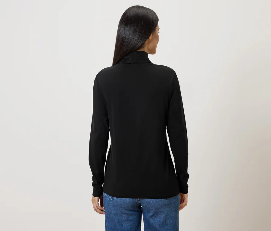 Vue arrière d'une femme aux longs cheveux foncés portant un pull à col roulé noir et un jean bleu.