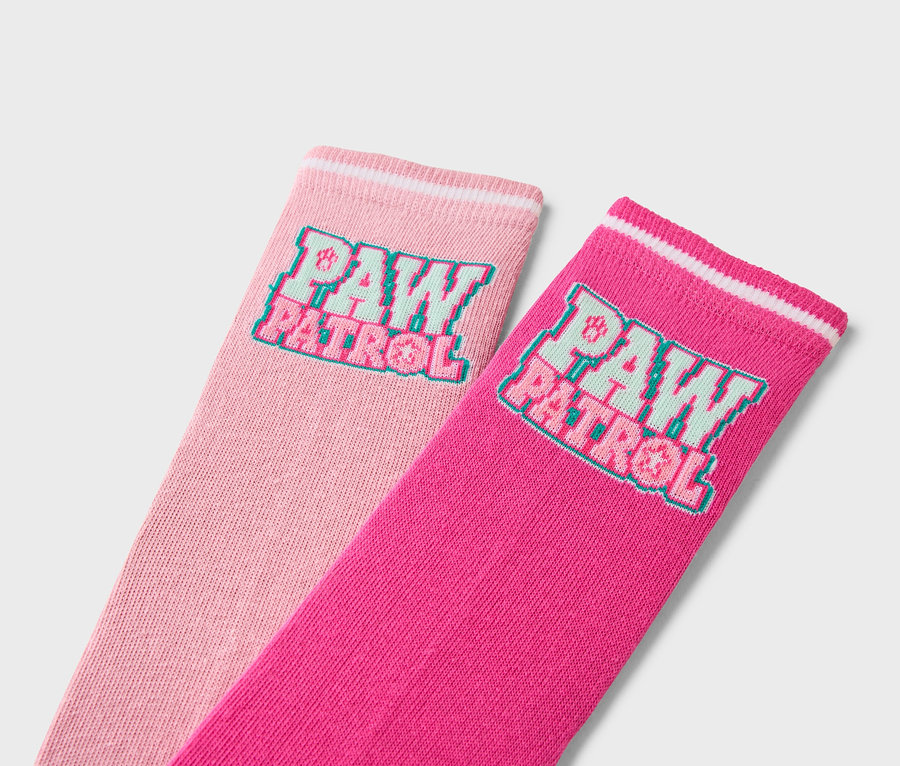 Gros plan de deux paires de chaussettes avec le logo Paw Patrol, une rose et une rose.